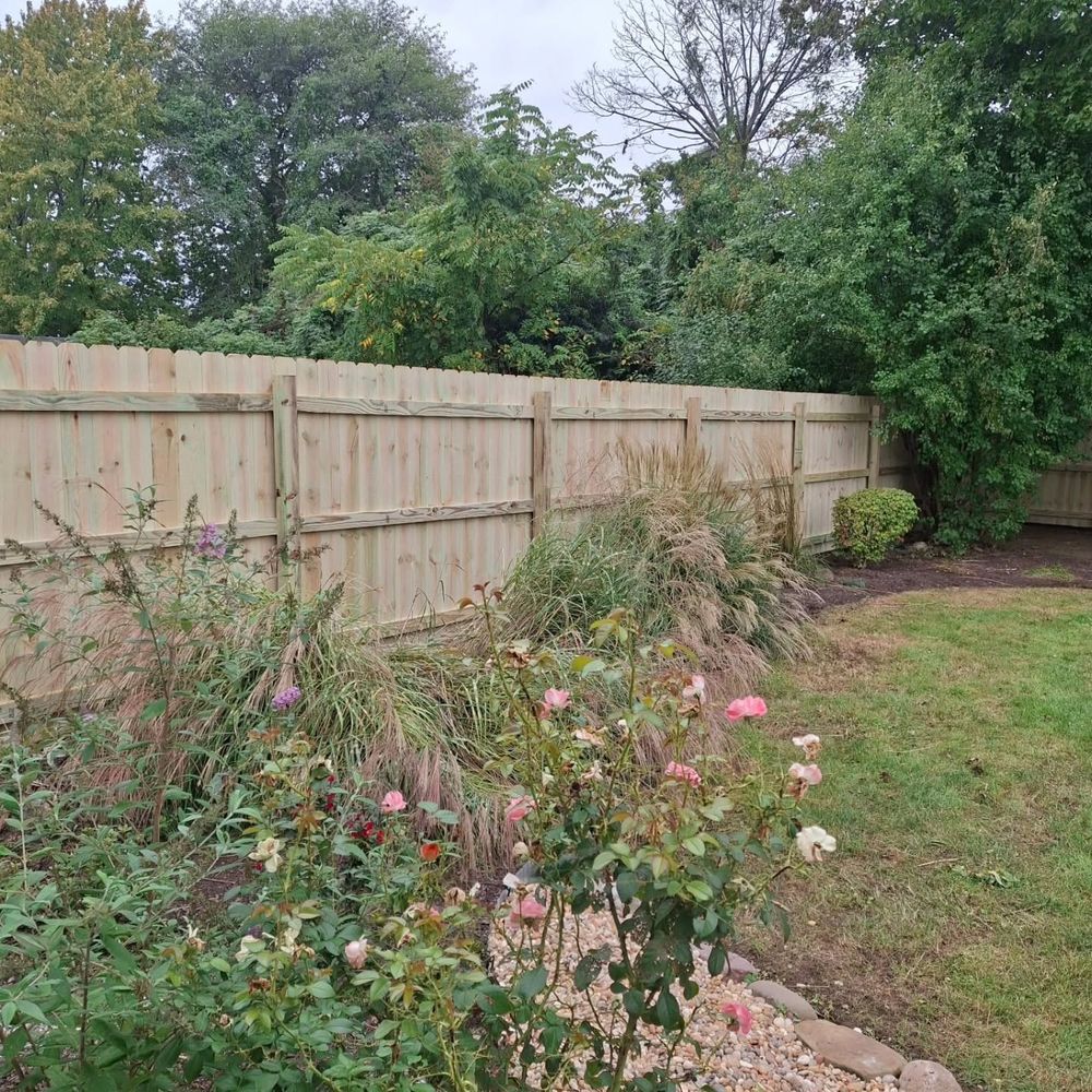 Wood privacy fence behind a flower garden