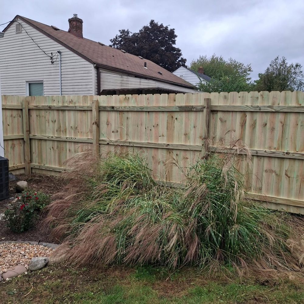 Wood privacy fence behind a house and ornamental grass