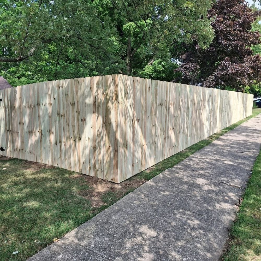 Long new wood privacy fence along a sidewalk